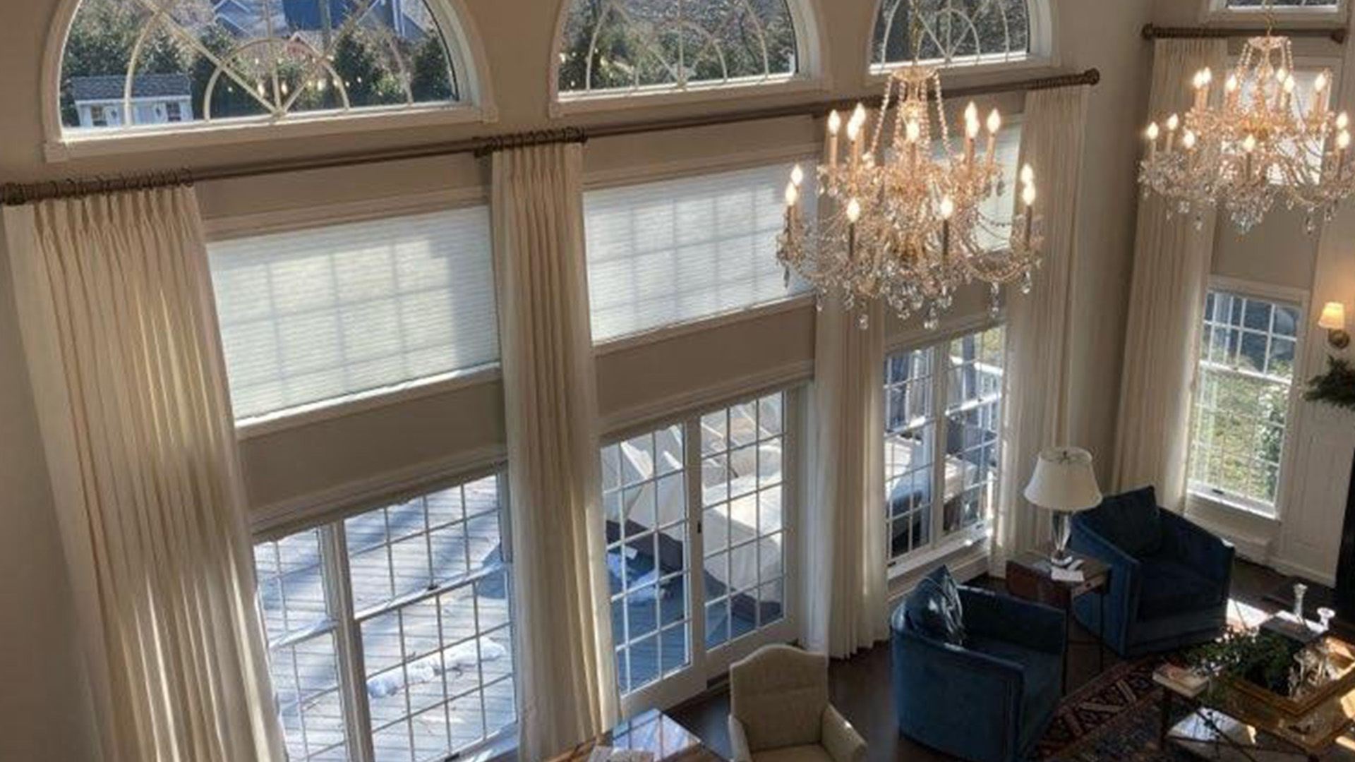 Drapery layered over shades in a bedroom.