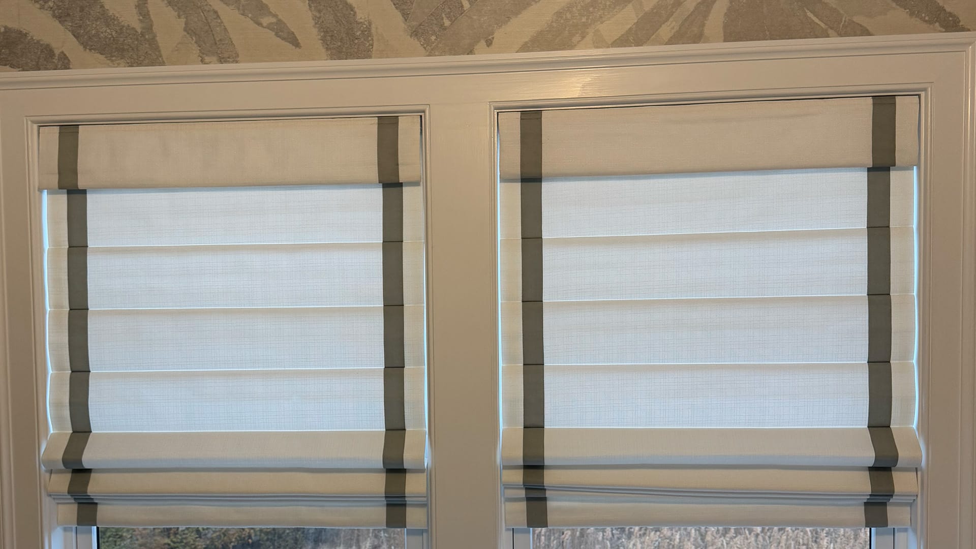 Roman shades lowering from behind a traditional valance.
