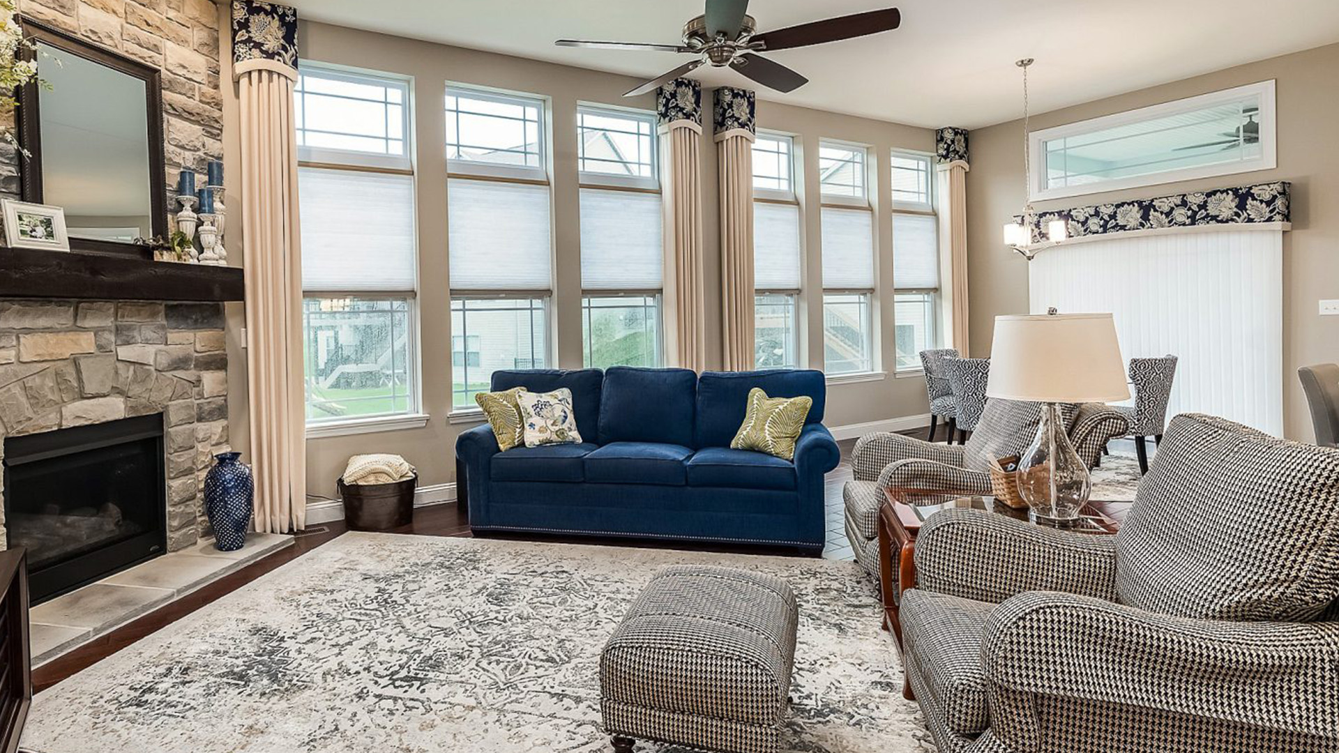 Layered Roman shades and drapery in a luxury bedroom.
